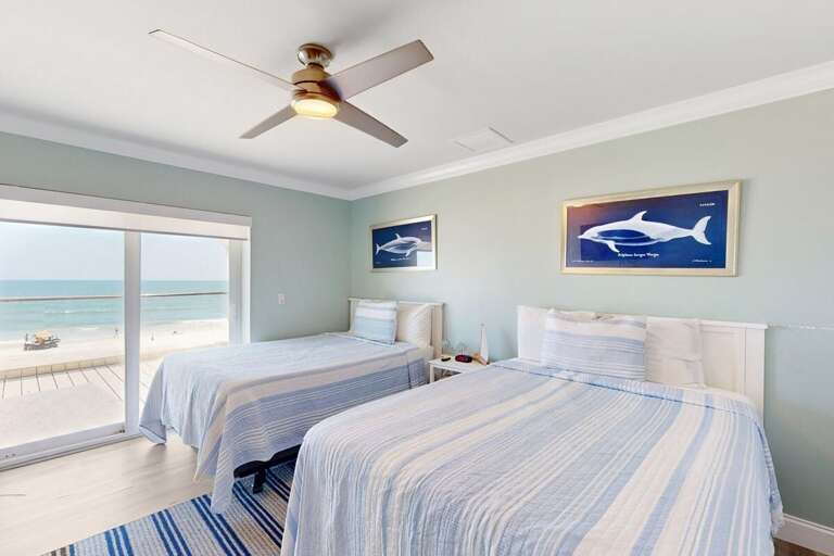 Wake up to stunning beach views in this calming oceanfront bedroom. Soft coastal tones, comfy beds, and floor-to-ceiling windows create the perfect beach-stay retreat.