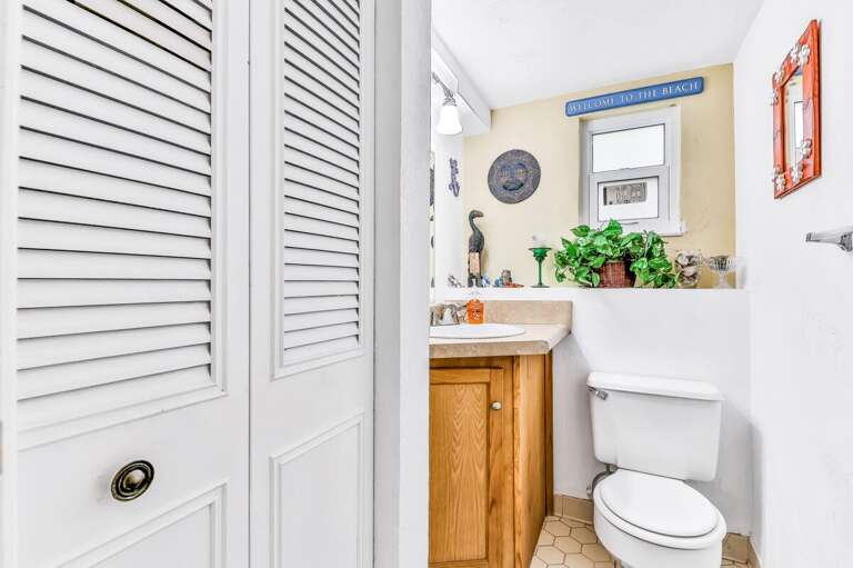 Bright beach-inspired bathroom with cheerful décor, natural light, and essentials for a refreshing stay. A welcoming touch that enhances your relaxing beach getaway.