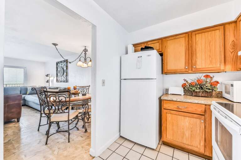 A bright, beach-stay kitchen flows into a charming dining area with coastal décor. Perfect for enjoying home-cooked meals before heading out to the sand and surf.