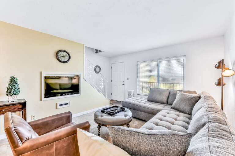 Relax in this inviting beach stay living room featuring a plush sectional, cozy seating, and plenty of natural light—perfect for unwinding after a day on the sand and surf.