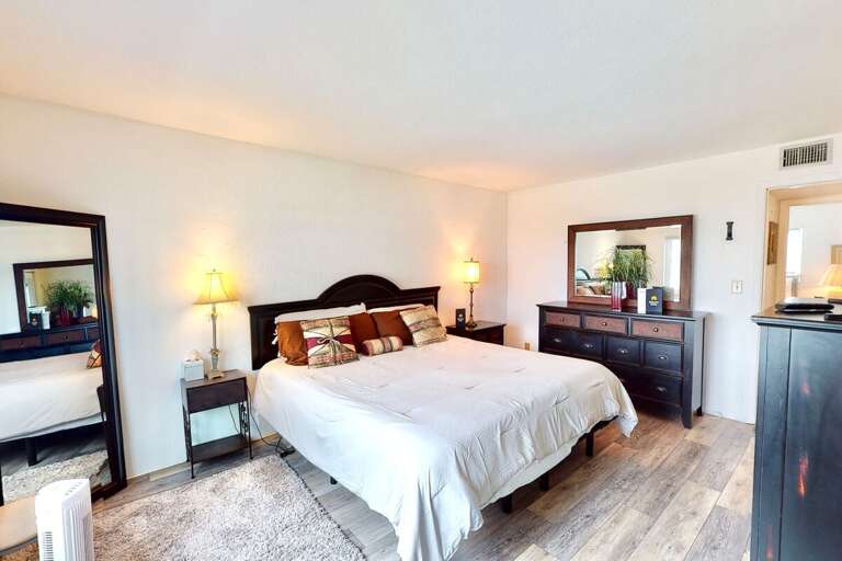 Unwind in this bright beachside king bedroom featuring warm décor, ample storage, and relaxing coastal style—perfect for a restful end to your oceanfront stay.