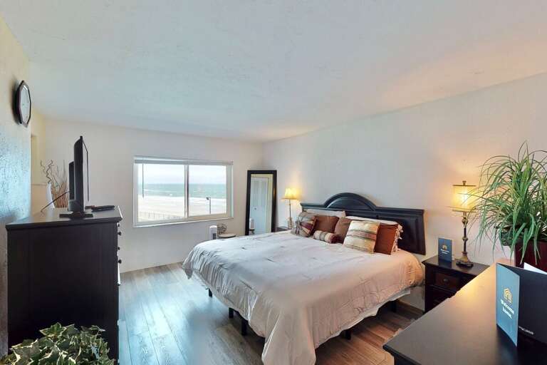 Wake up to stunning ocean views in this spacious beachside bedroom, featuring a plush king bed, cozy lighting, and relaxing coastal vibes—perfect for unwinding after a day on the sand.