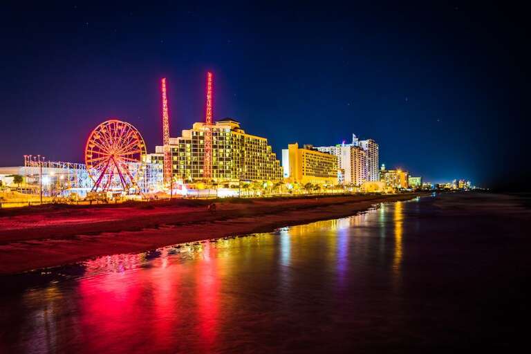 Nighttime Cityscape With Luminous Buildings And Ferris Wheel By Riverside