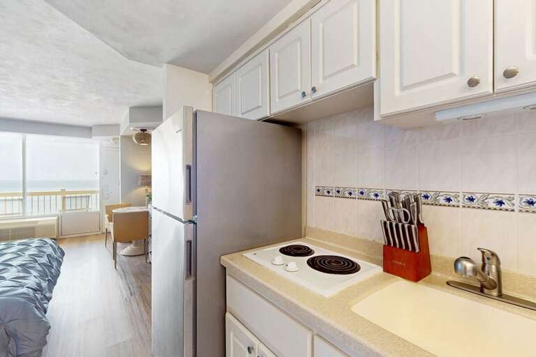 Small, Streamlined Space Showing Kitchen And Living Area With Balcony View