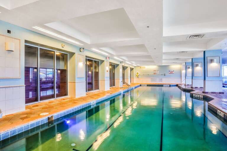 Luminous Indoor Pool With Glass Walls And Tiled Deck