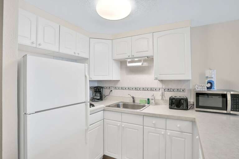 Bright, Basic Kitchen With White Appliances And Cabinets