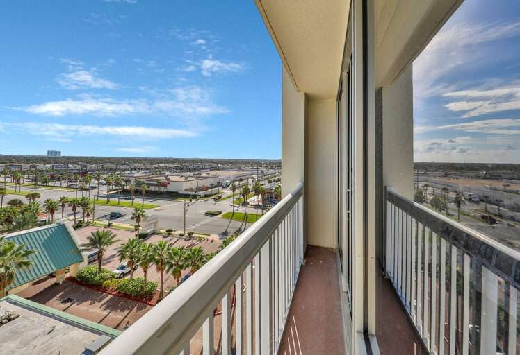 Balcony View With Blue Skies Above Bustling Cityscape
