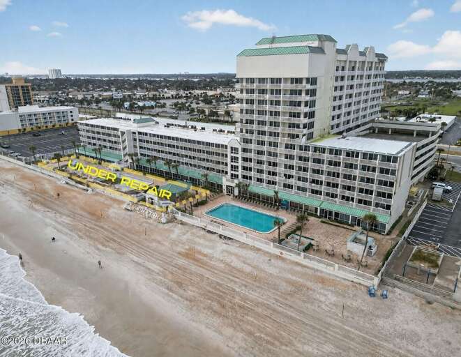 Aerial view of the oceanfront condominium complex, highlighting the beachfront setting, pool deck, spacious grounds,  Please note that portions of the beachfront area are currently under repair.