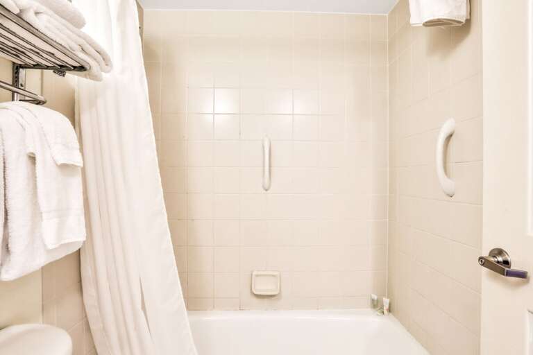 Simple Bathroom In Vacation Rental With Towels And Tub