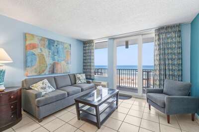 Relax in this bright oceanfront living room featuring comfortable seating, coastal décor, and