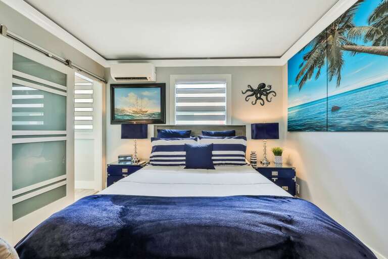 Bedroom With Blue Bedding And Beach-themed Mural
