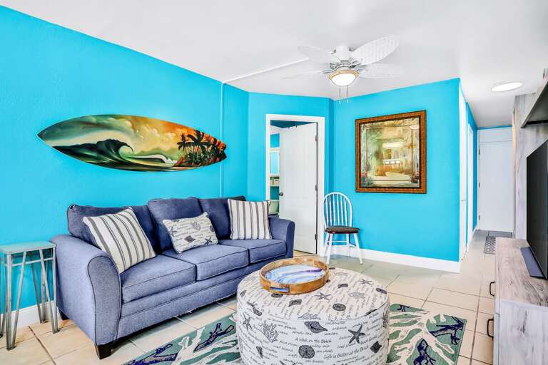 Bright Blue Living Space With Beach-themed Decor And Grey Sofa