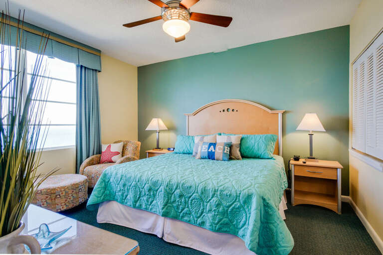 Cheerful beach-themed bedroom featuring a plush king bed, ocean-inspired décor, and soft natural light—perfect for unwinding after a day of seaside adventures during your beach stay.