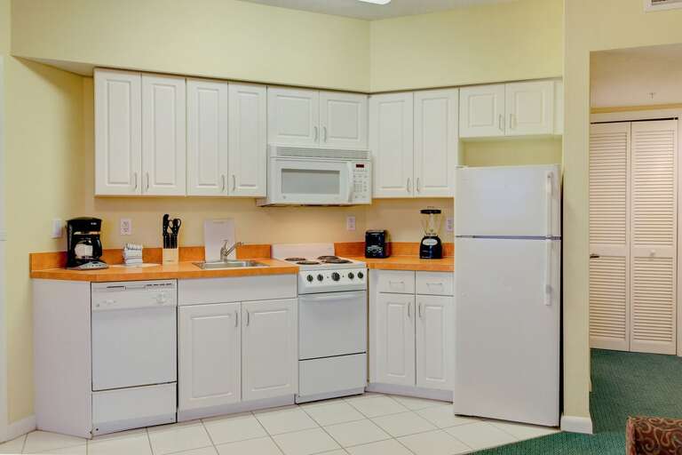 Clean, fully equipped beach stay kitchen with bright cabinetry, full-size appliances, and all essentials for seaside vacation cooking. Perfect for easy meals after a day in the sun.