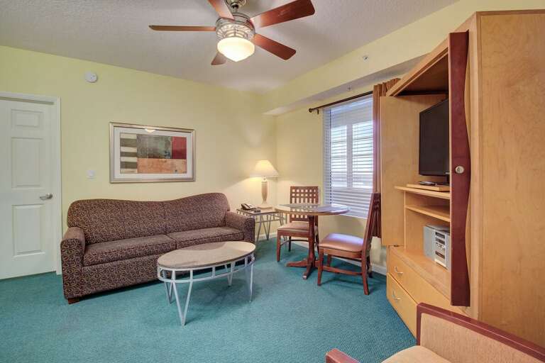 Comfortable beach-style living area with cozy seating, warm lighting, and a small dining nook—perfect for relaxing after a day of sun and ocean adventures.