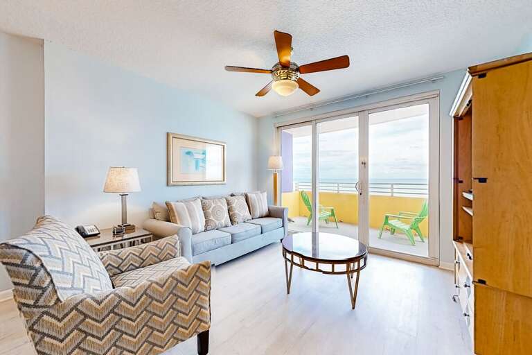 Relax in this airy beach-stay living room featuring coastal décor, comfy seating, and floor-to-ceiling views. Step onto the oceanfront balcony for fresh sea breezes and stunning shoreline scenery.