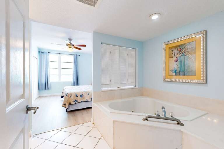 Relax after a day of beachfront fun in this spacious bathroom featuring a large soaking tub and serene ocean-inspired décor—perfect for unwinding during your beach stay.