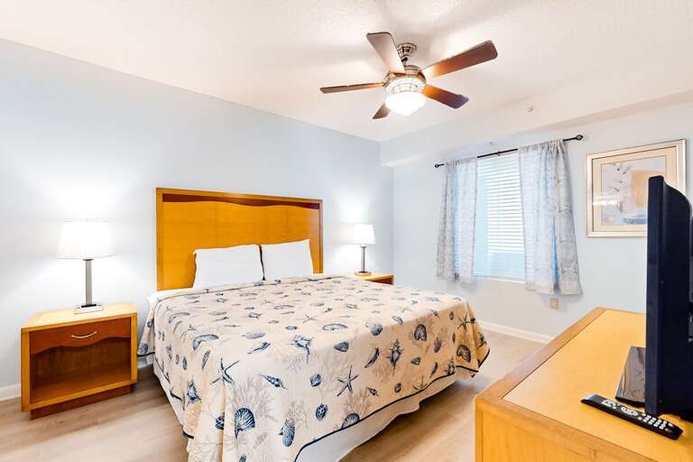 Relax in this beach-inspired bedroom featuring a king bed with seashell décor, soft natural lighting, and soothing coastal tones—perfect for unwinding after a sun-filled beach stay.