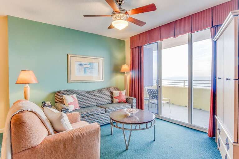 Relax in this sunny beachside living room featuring cozy seating, vibrant coastal décor, and direct access to a private oceanfront balcony—perfect for enjoying your beach stay sunrise or sunset.