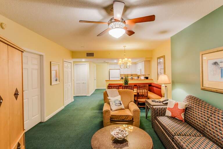 Warm beach-style living and dining space with cozy seating, vibrant décor, and an open layout leading to the kitchen—perfect for relaxing after a fun-filled day by the ocean.