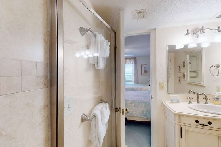 This convenient ensuite bathroom features a walk-in shower, bright vanity, and soft coastal décor—adding comfort and ease to your relaxing beach stay.