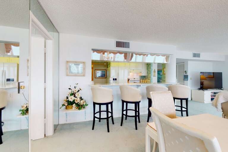 Enjoy a relaxed beach stay with this inviting breakfast bar, offering comfy seating and a bright, open view into the coastal kitchen—perfect for casual meals and conversations.
