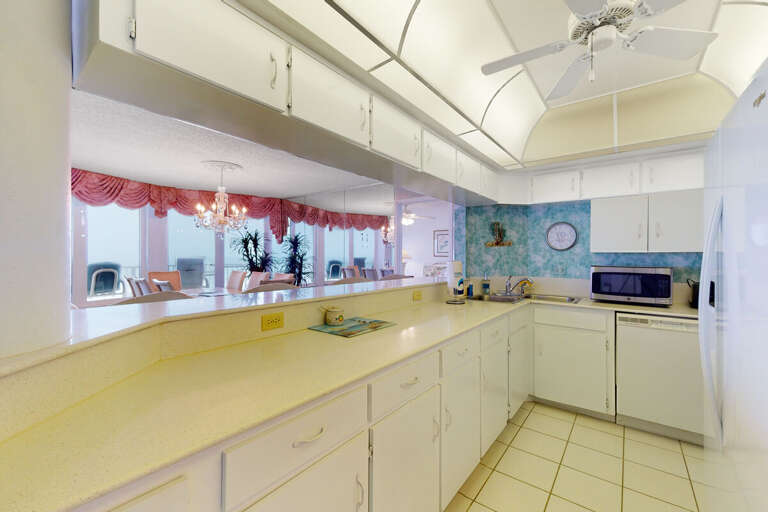 This spacious coastal kitchen features ample counter space, bright lighting, and an open view into the living and dining areas—perfect for easy meal prep during your beach stay.