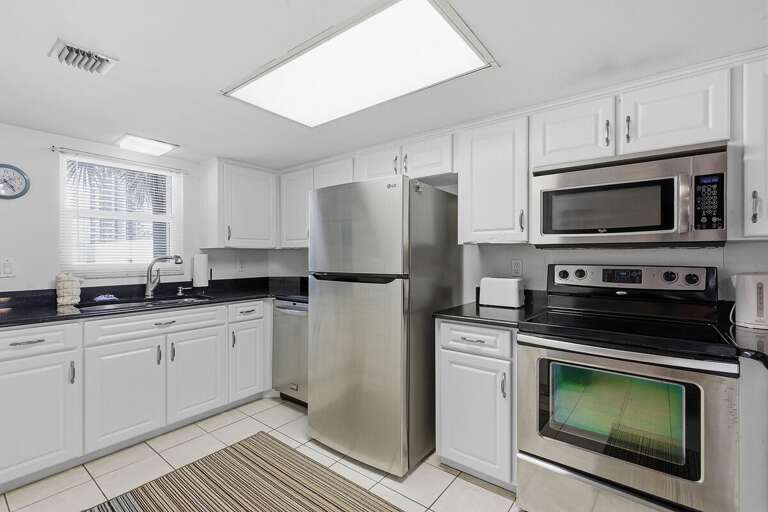 Prepare meals with ease during your beach stay in this bright, fully equipped kitchen featuring