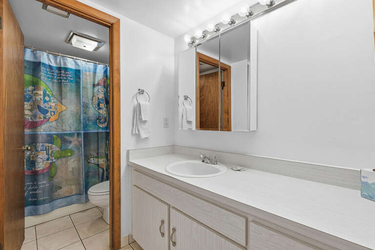 Refresh during your beach stay in this clean, bright bathroom featuring a spacious vanity, ample