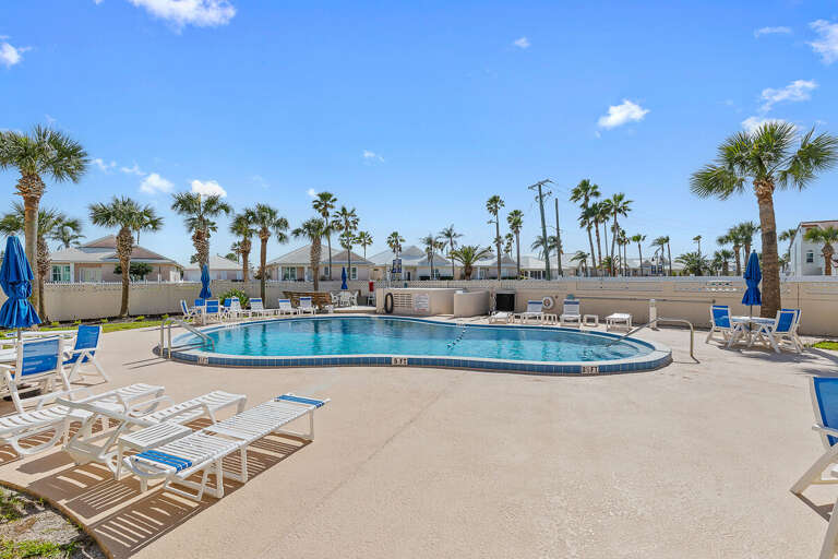 Soak up the sun during your beach stay at this inviting resort-style pool with lounge chairs and palm-lined views. A perfect spot to relax, swim, and enjoy coastal vibes just moments from the beach.