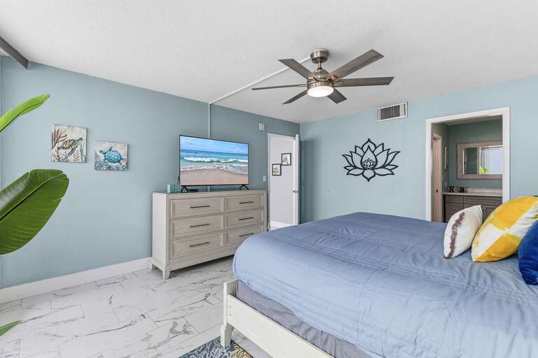 Recharge in this spacious king bedroom featuring coastal décor, a Smart TV, and a private ensuite