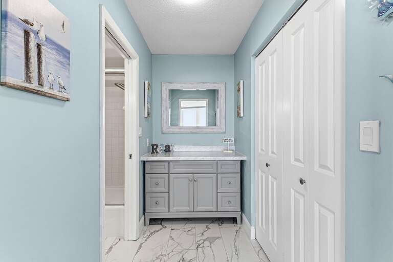 Refresh in this bright coastal ensuite bathroom featuring a spacious vanity, ample storage, and a