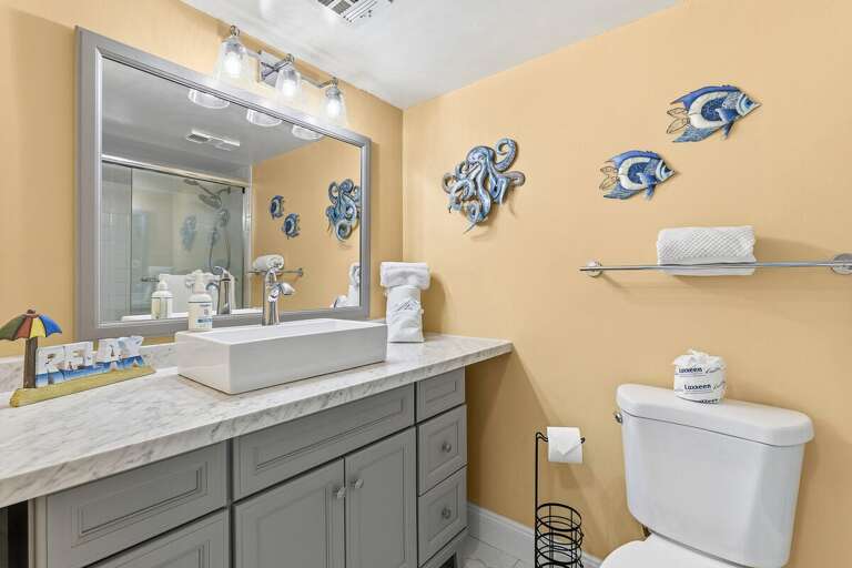 Refresh in this coastal-inspired bathroom featuring a modern vanity, spacious countertop, and