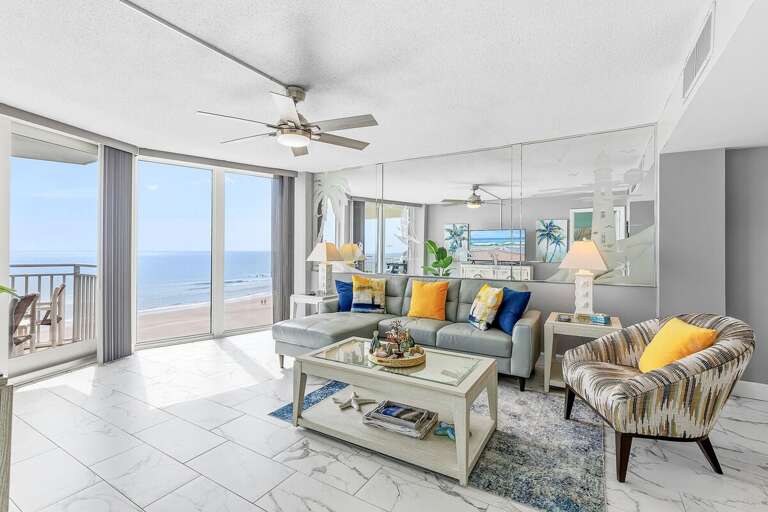 Unwind in this bright oceanfront living room featuring floor-to-ceiling windows, comfortable