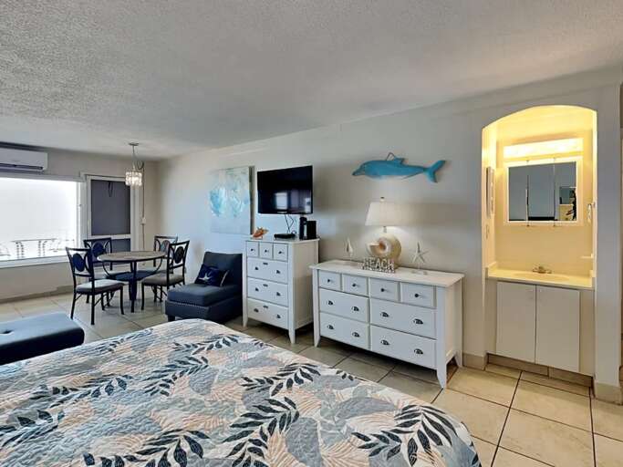 Relax in this airy beachside studio featuring coastal décor, dining area, flat-screen TV, and comfy furnishings—perfect for unwinding after a day of sun, sand, and sea breezes.