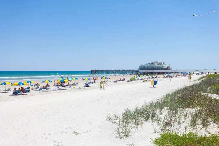 Soak up the sun on the pristine beach just outside your stay. With soft sand, colorful umbrellas, and the pier nearby, it's the perfect setting for your beach vacation.