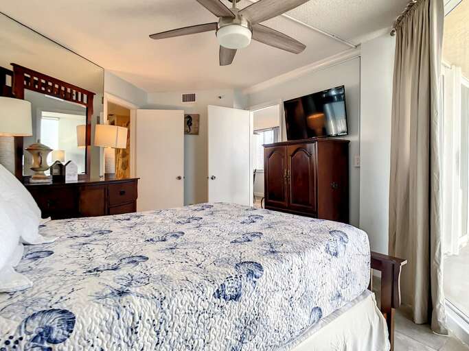 Spacious bedroom featuring a comfortable bed, modern decor, and balcony access with serene ocean views.