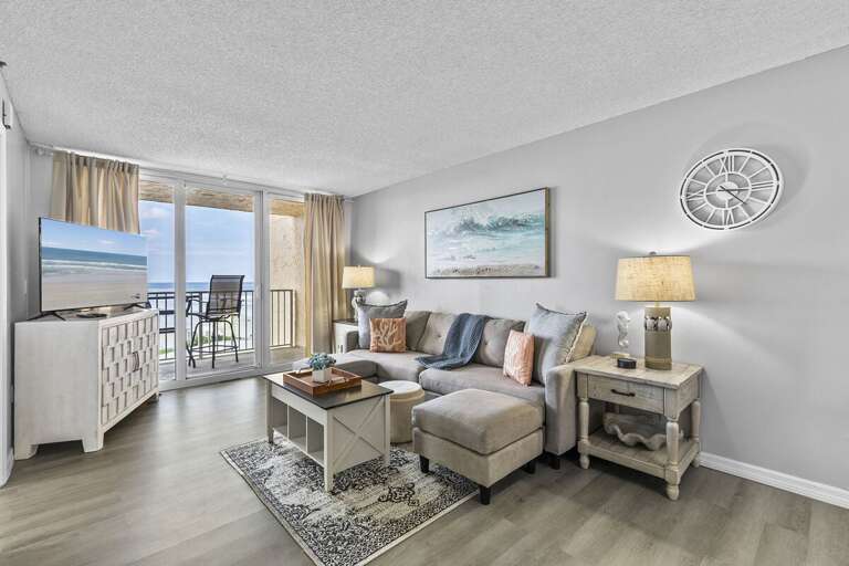 This inviting living room offers a perfect blend of comfort and coastal charm. A plush sectional