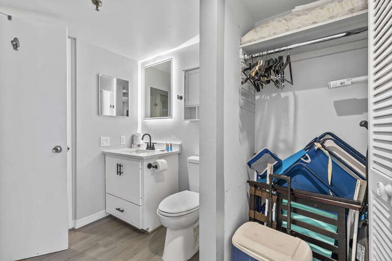 This modern bathroom features a sleek vanity, illuminated mirror, and contemporary fixtures.
