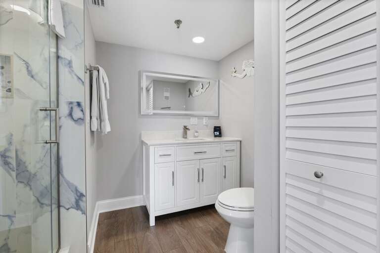 A chic bathroom featuring a marble shower and sleek vanity for a refreshing experience.