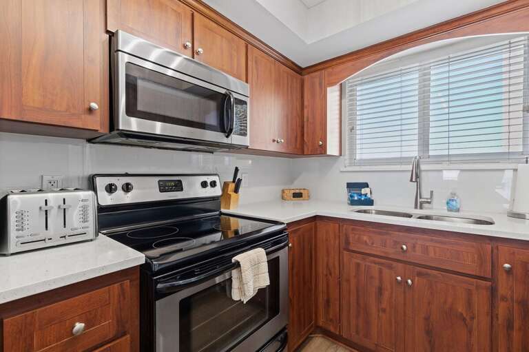 Well-equipped kitchen with a microwave, toaster, and double sink for culinary convenience.