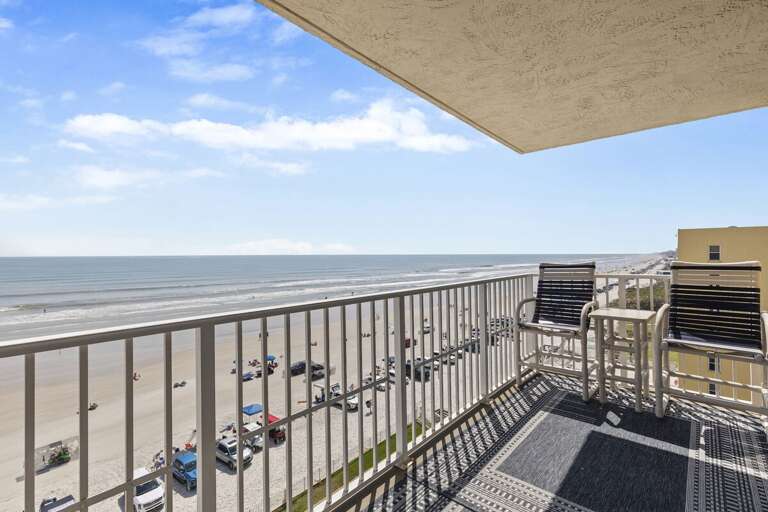 Spacious balcony with comfortable seating and sweeping views of the beach and ocean.