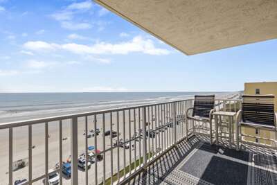 Spacious balcony with comfortable seating and sweeping views of the beach and ocean.