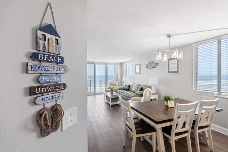 Wall decor highlights the relaxing, beach-inspired vibe of this serene living space.