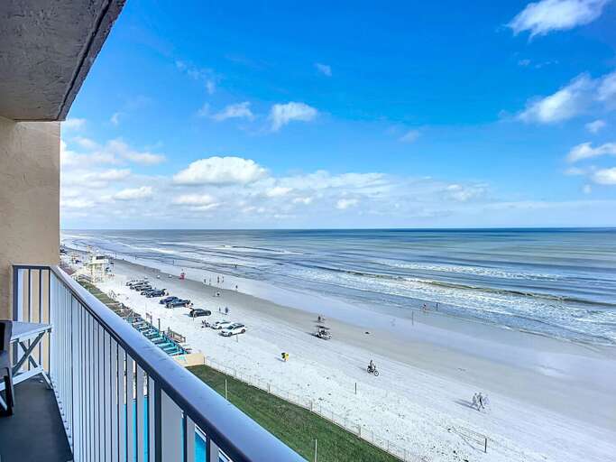 Relax with breathtaking ocean vistas, sandy shores, and blue skies from a private balcony overlooking the serene coastline. Perfect for a tranquil getaway.