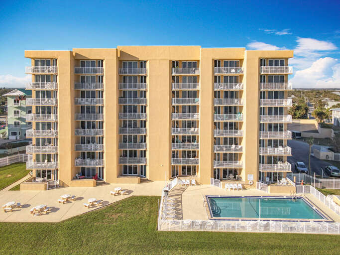 This contemporary beachfront property boasts spacious balconies, a sparkling pool, and inviting outdoor spaces, perfect for a relaxing seaside vacation.