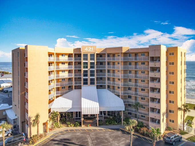 Experience coastal living in this stunning beachfront condominium featuring private balconies, lush landscaping, and direct access to the ocean for a perfect getaway.