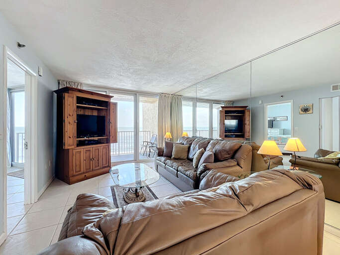 Relax in comfort with plush seating, abundant natural light, and direct access to a balcony overlooking the serene ocean horizon.