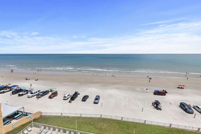 Enjoy expansive views of the shoreline, where sand meets sea under a clear blue sky.