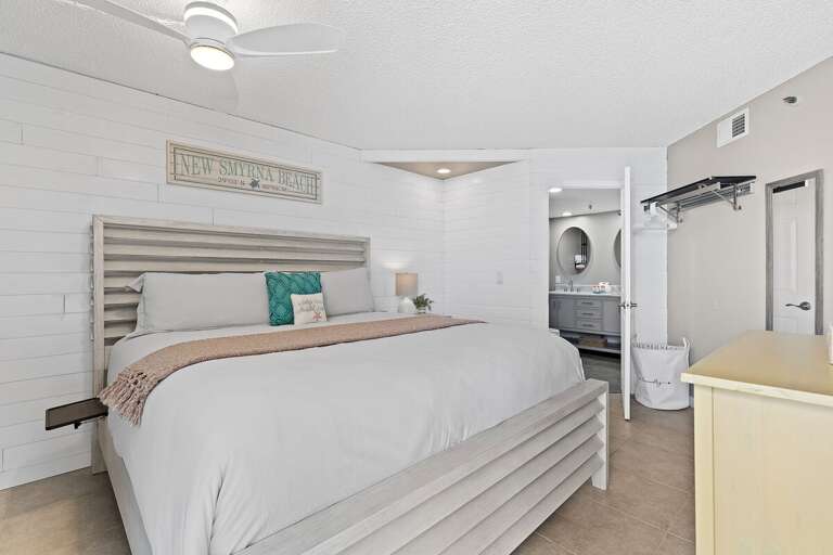 Relax in a bright, airy bedroom featuring a king bed, private bath, and coastal decor.